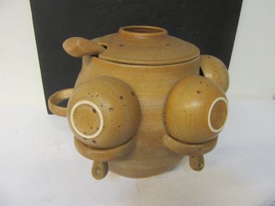 un pot marron orné de deux yeux, posé sur une table