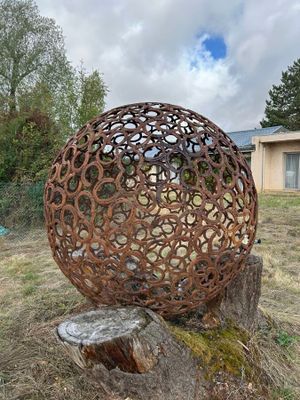 une grosse boule métallique posée sur une souche d'arbre