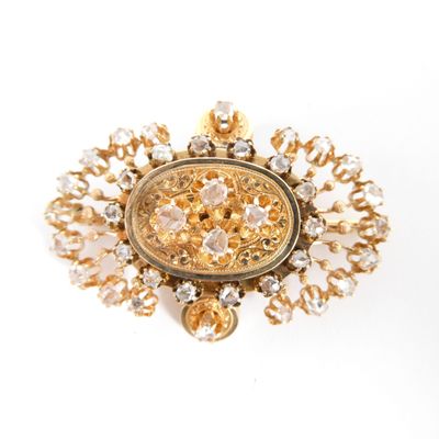 une image d'une broche en or et diamants sur fond blanc