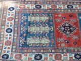 an oriental rug with a blue and red design on a wooden floor