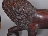 a lion statue next to a vase on a table