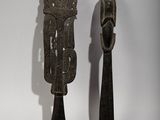pair of wooden spoons with carvings on them sitting next to each other