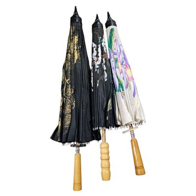 three umbrellas that are hanging on a wooden pole