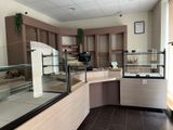 a picture of a bakery with a counter and a glass case