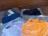 a pile of clothes on a table with plastic bags