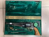 une mallette verte contenant un pistolet et d'autres objets