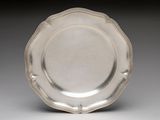 silver plate with scalloped edge on a gray background