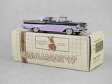 une maquette de voiture violette et noire posée sur une boîte en carton