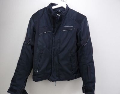 the jacket is hanging on a hanger on the wall