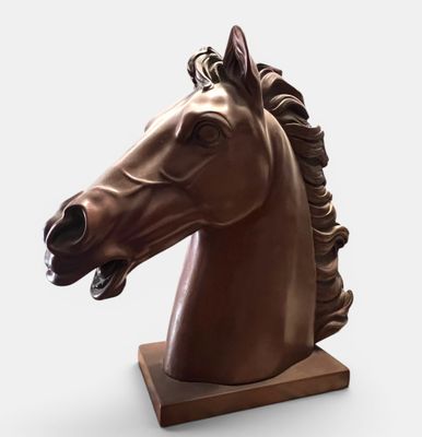statue of a horse head on a wooden base on a white background