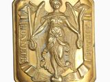 an image of a gold plate with a statue of a woman holding a sword