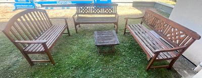 trois bancs en bois et une petite table dans l'herbe
