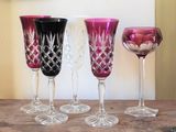 quatre verres à vin posés sur une table à côté d'une assiette