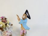 two figurines of a man and a woman with hats on