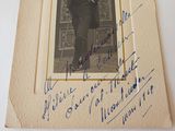 an old photo of a man in a suit and tie holding a cane