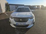 the front view of a white car parked in a parking lot