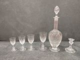 five wine glasses and a decanter on a table