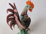 a figurine of a rooster on a white table
