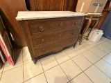une commode avec un plateau en marbre au milieu d'une pièce