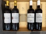 Il y a trois bouteilles de vin dans une boîte posée sur une table