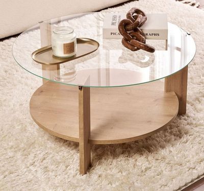 une table basse avec un plateau en verre posée sur un tapis