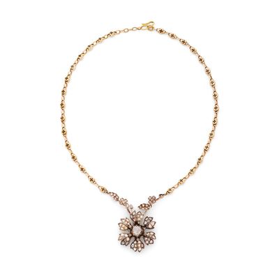 un collier en or avec un pendentif en forme de fleur au bout d'une chaîne