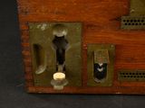 a small wooden box with a keyhole and a hole in it