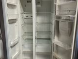 an open refrigerator sitting on a pallet in a warehouse