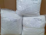 quatre sacs contenant des oreillers blancs posés sur un carton