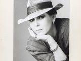 black and white photograph of a woman wearing a hat with her hand on her chin