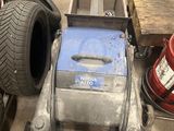 une machine posée par terre à côté de quelques pneus