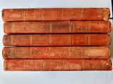 six vieux livres sont empilés sur une table