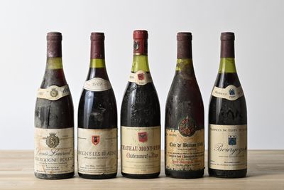 six bottles of wine are lined up on a wooden table