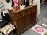 une table en verre sur laquelle se trouve un vase, à côté d'une commode