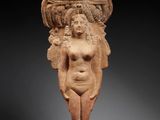 une figurine égyptienne en terre cuite représentant une femme avec un panier sur la tête