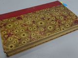 an old book with a red cover sitting on a table
