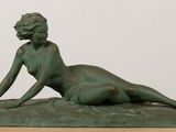 statue représentant une femme allongée sur un rocher posé sur une table