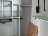 une photo d'un dressing équipé d'étagères et d'une porte