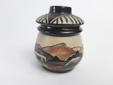 a black and white vase with a mountain scene on it