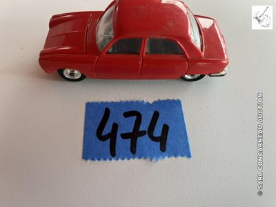 une petite voiture rouge posée à côté d'une feuille de papier bleue