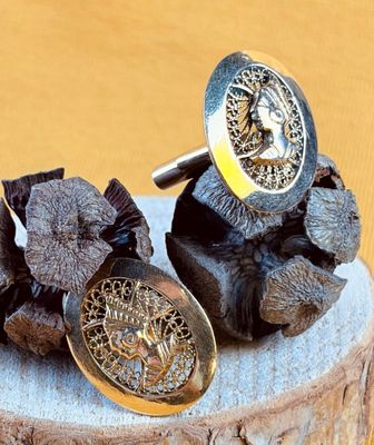a pair of cufflinks that are on top of a tree stump