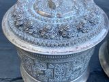 une boîte en argent avec un couvercle, posée sur une table