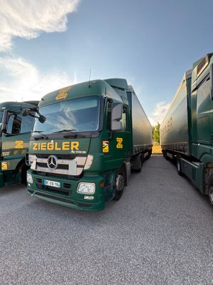 three green trucks parked next to each other in a parking lot