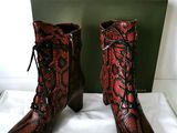 des bottes en peau de serpent rouges et noires, ornées de lacets noirs