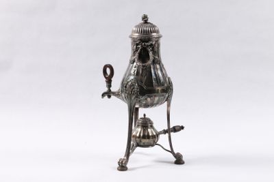 une théière en argent munie d'une anse et posée sur un socle