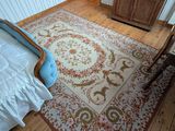 un lit et une commode dans une chambre où il y a un tapis au sol