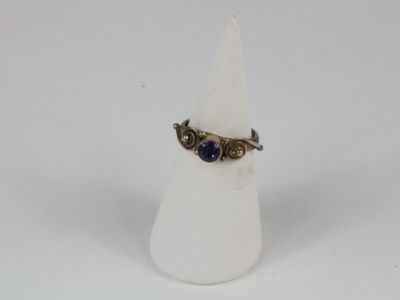an image of a ring with a blue stone sitting on top of a white cone