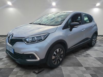 une voiture argentée garée dans un garage au sol en damier