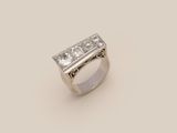 a close up of a diamond ring on a white surface