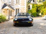 a black sports car parked in front of a house